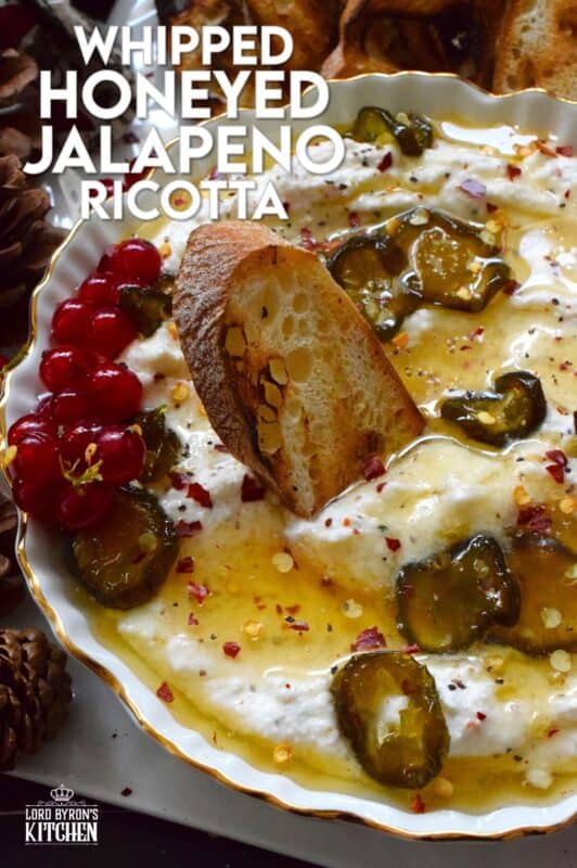 When you whip ricotta with garlic, onion, oregano, and sour cream, not only is the flavour incredible, but the texture is silky smooth.  Topped with homemade Jalapeno Honey, this dip is cool and spicy at the same time.  Serve with your favourite crackers and bread. #ricotta #appetizer #spread #dip #cheese #honey #jalapeno