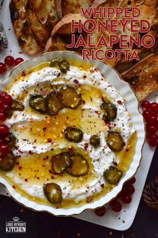 When you whip ricotta with garlic, onion, oregano, and sour cream, not only is the flavour incredible, but the texture is silky smooth.  Topped with homemade Jalapeno Honey, this dip is cool and spicy at the same time.  Serve with your favourite crackers and bread. #ricotta #appetizer #spread #dip #cheese #honey #jalapeno