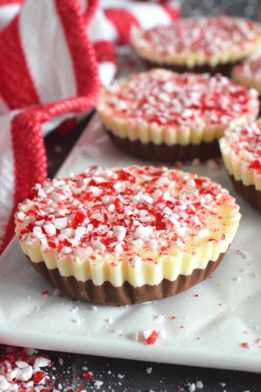 If you can melt chocolate, you can easily make these Muffin Tin Peppermint Cups!  A layer of melted milk chocolate is followed by a layer of white melted chocolate and topped with a generous amount of crushed red and white candy canes.  Decadent and rich, these festive treats are both fun to prepare and to eat! #melted #chocolate #milk #white #candycane #peppermint #nobake