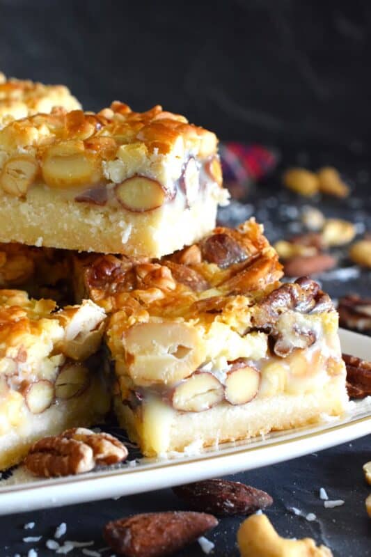 There are so many versions of these layered types of squares, but this one is unique in the way that it uses a store-bought boxed cake mix for the base. You don't need to bake the cake first! Deliciously sweet and sticky Caramel and Salted Nut Squares are so quick and easy to make! #squares #bars #layered #condensed #milk #caramel #nuts #salted