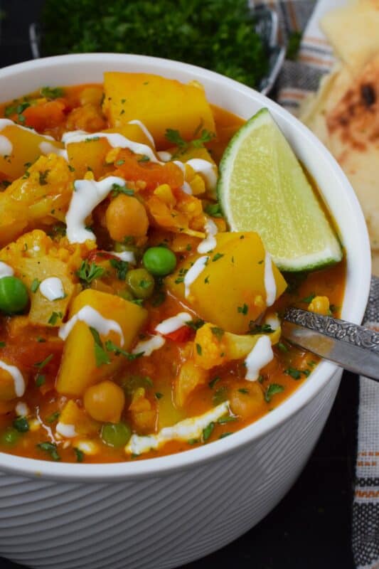 Chickpea Coconut Curry Soup is everything but bland; prepared with lots of vegetables, warming spices, and a fresh burst of lime juice, this soup is also vegetarian and vegan-friendly too! Serve with naan bread for a well-balanced, hearty meal! #curry #coconut #soup #stew #vegan